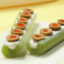 Olive slices and cream cheese on two celery sticks